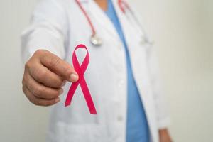 cancer du sein, femme médecin asiatique avec ruban rose, symbole de la journée mondiale du cancer du sein. photo