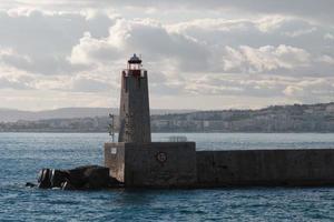 phare dans le port, paysage marin. balise, mer et nuages au coucher du soleil, nice, france. photo