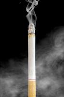 une cigarette debout isolée avec de la fumée