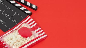panneau de clapet noir ou ardoise de film et sac de maïs soufflé rouge sur fond rouge. photo