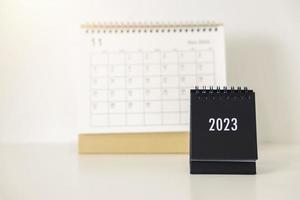 Calendrier d'affaires 2023 sur la table de bureau le jour du nouvel an. établir un plan de travail pour le début de l'année. concept sur la célébration, les affaires, noël, nouvel an. photo