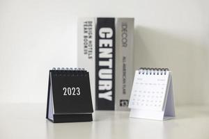 Calendrier d'affaires 2023 sur la table de bureau le jour du nouvel an. établir un plan de travail pour le début de l'année. concept sur la célébration, les affaires, noël, nouvel an. photo