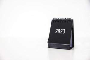 Calendrier d'affaires 2023 sur la table de bureau le jour du nouvel an. établir un plan de travail pour le début de l'année. concept sur la célébration, les affaires, noël, nouvel an. photo