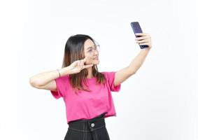 prendre un selfie à l'aide du smartphone d'une belle femme asiatique isolée sur fond blanc photo