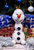 bonhommes de neige tricotés dans des chapeaux et des écharpes colorés sur fond bleu. le concept de noël, du nouvel an et du conte de fées d'hiver. photo