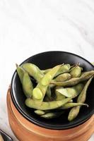 Edamame congelé à la vapeur sur tableau blanc photo