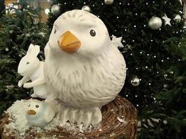 le poussin en plastique vole sous l'arbre de Noël photo