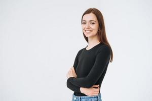 Portrait of happy young beautiful woman with dark long hair in black longsleeve and jeans on white background isolated photo