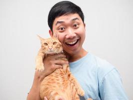 homme asiatique se sentant heureux tenant un joli portrait de chat fond blanc photo