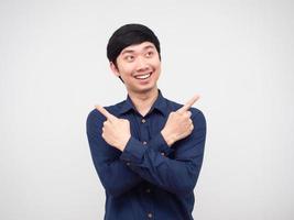 homme asiatique souriant bras croisés et doigt regardant l'espace portrait fond blanc photo