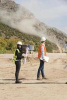 l'ingénieur géomètre mesure le niveau sur le chantier de construction. les géomètres assurent des mesures précises avant d'entreprendre de grands projets de construction. photo