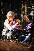 heureuse grand-mère, petite-fille et petit-fils jouant dans le parc photo