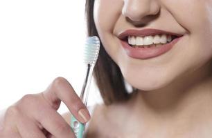 Portrait of attractive smiling woman isolated on white studio shot se brosser les dents photo