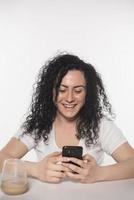 Portrait d'une femme heureuse à l'aide de téléphone mobile isolé sur fond blanc photo