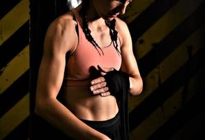 gros plan d'une femme faisant des bandages de boxe dans une cage de combat photo