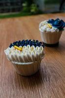 cupcakes luxueux et élégants, avec de la crème blanche et du bleu marine avec des pépites d'or. photo