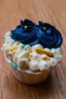 cupcakes luxueux et élégants, avec de la crème blanche et du bleu marine avec des pépites d'or. photo