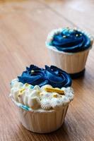 cupcakes luxueux et élégants, avec de la crème blanche et du bleu marine avec des pépites d'or. photo