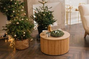 plusieurs arbres de noël élégants se dressent dans le salon près de la cheminée en marbre photo