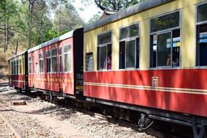 petit train se déplaçant sur les pentes de la montagne, belle vue, un côté montagne, un côté vallée se déplaçant sur le chemin de fer jusqu'à la colline, parmi la forêt naturelle verdoyante. train jouet de kalka à shimla en inde, train indien photo