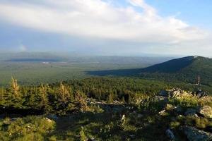 voyage dans les montagnes de l'oural, en russie. la vue depuis un sommet sur les montagnes, la forêt et le ciel nuageux. photo