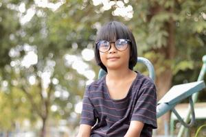 enfant portant des lunettes sur fond de nature floue photo