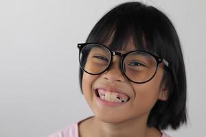 portrait d'enfant portant des lunettes sur fond blanc. photo