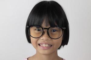 Portrait d'enfant portant des lunettes sur fond blanc photo