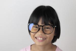 Portrait d'enfant portant des lunettes sur fond blanc photo