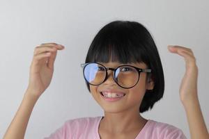 Portrait d'enfant portant des lunettes sur fond blanc photo