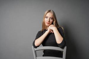 jeune femme sereine assise à califourchon sur une chaise photo