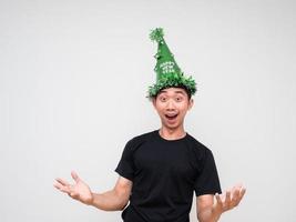 bonheur homme chemise noire avec chapeau vert joyeux et montrer la main sur fond blanc célébration bonne année concept photo