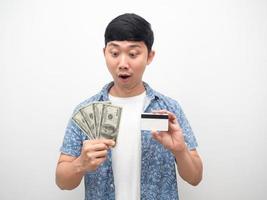 un homme regardant de l'argent et une carte de crédit en main se sent excité isolé photo
