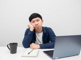 homme assis à la table avec un ordinateur portable sur le lieu de travail se sentant ennuyé photo