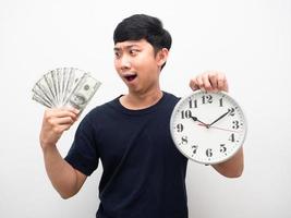 homme asiatique tenant une horloge analogique et regardant beaucoup d'émotion étonnée d'argent photo