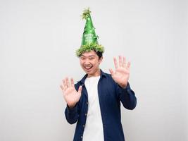 homme asiatique portant un chapeau vert geste montrer la main vers le haut concept de célébration du nouvel an photo