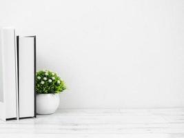 livres et petit vase sur une table en bois blanc espace de copie de style minimal mur blanc, espace de travail à la maison photo