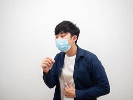 L'homme thaïlandais avec un masque de protection contre la toux se sent mal et malade sur fond blanc isolé photo