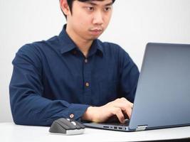 homme asiatique travaillant avec son ordinateur portable sur la table à la maison photo