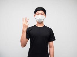 homme asiatique chemise noire avec masque montrer trois doigts comptant sur fond blanc isoated photo