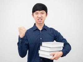 homme asiatique confiant montrer le poing vers le haut et tenant un livre à la main portrait fond blanc photo