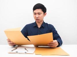 homme asiatique se sentant mal à la tête à propos de nombreux documents sur la table fond blanc photo