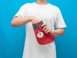 Crop shot of man push hand in christmas stocking blue backgrond photo