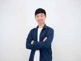 homme asiatique debout bras croisés sourire heureux au portrait de fond de mur blanc photo