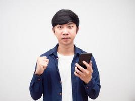 jeune homme asiatique se sentant en colère et montre le poing nad téléphone portable blanc isolé photo