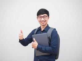 homme d'affaires asiatique tenant un ordinateur portable avec sac à dos sourire heureux montrer le pouce vers le haut sur fond blanc