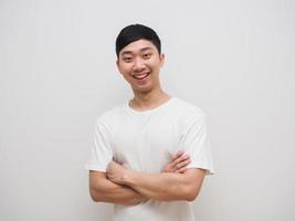 homme asiatique chemise blanche bras croisés avec sourire heureux et rire au visage sur fond blanc isoalte photo