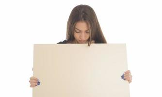 jeune fille souriante tenant un panneau vierge. portrait en studio de jeune femme avec carte de signe. isolée. photo