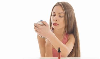 portrait de jeune fille peignant ses lèvres avec le rouge à lèvres lumineux photo