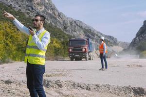 l'ingénieur géomètre mesure le niveau sur le chantier de construction. les géomètres assurent des mesures précises avant d'entreprendre de grands projets de construction. photo